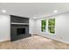Living room with black brick fireplace, white walls, and newer wood look flooring at 6839 Wagon Oak Rd, Charlotte, NC 28212