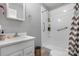Clean, all-white bathroom featuring a modern vanity, storage, and walk-in shower with shelving at 701 5Th Ne Ave, Conover, NC 28613