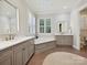 Bright bathroom features double vanities, a soaking tub, neutral color palette, and natural light at 7011 Conservatory Ln, Charlotte, NC 28270