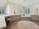 Bathroom featuring double vanities, a soaking tub, neutral color palette, and natural light at 7011 Conservatory Ln, Charlotte, NC 28210
