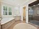 Bathroom with double vanities, soaking tub, glass shower, neutral palette, and natural light at 7011 Conservatory Ln, Charlotte, NC 28210