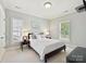 Light-filled bedroom with a large bed, two windows with blinds, and neutral gray paint at 7011 Conservatory Ln, Charlotte, NC 28210