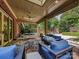 Enjoy this expansive covered patio featuring comfortable seating, a dining area, and a beautiful brick surround at 7011 Conservatory Ln, Charlotte, NC 28210