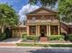 Charming brick home featuring a two-car garage, lush landscaping, and a welcoming front porch at 7011 Conservatory Ln, Charlotte, NC 28210