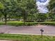 Beautiful landscaped front yard with mature trees and green lawns, offering a serene view at 7011 Conservatory Ln, Charlotte, NC 28210