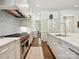 Modern kitchen featuring stainless steel appliances, white cabinetry, and a light blue tile backsplash at 7011 Conservatory Ln, Charlotte, NC 28210