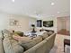 Spacious living room featuring a large sectional sofa, TV, exercise equipment, and neutral decor at 7011 Conservatory Ln, Charlotte, NC 28270