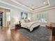 Spacious main bedroom with tray ceiling, ceiling fan, and a large window for natural light at 7011 Conservatory Ln, Charlotte, NC 28210