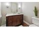 Powder room with dark wooden vanity, silver hardware, sconce lighting, and decorative textured wall at 7011 Conservatory Ln, Charlotte, NC 28210
