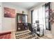 Well-lit home office featuring a glass desk, modern black chair, and elegant display cabinet at 8008 Brookbank Dr, Charlotte, NC 28269