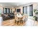 Open-concept area with dining table, sofa, decorative curtains and hard wood flooring at 8008 Brookbank Dr, Charlotte, NC 28269