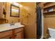 Cozy bathroom with classic vanity, wall mirror, and shower featuring unique dark wood paneling and a shower caddy at 908 Taylor St, Kannapolis, NC 28083