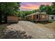 Charming single-story home featuring gravel driveway and spacious backyard, nestled among mature trees at 908 Taylor St, Kannapolis, NC 28083
