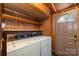 Fully equipped laundry room with washer, dryer, built-in shelving for optimal organization, and exterior door at 908 Taylor St, Kannapolis, NC 28083