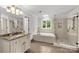 Spa-like bathroom with soaking tub, glass enclosed shower and marble countertops at 9513 Tresanton Dr, Charlotte, NC 28210