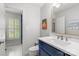 Clean bathroom featuring a blue vanity, white countertop, gold mirror, and a view into another tiled space at 9513 Tresanton Dr, Charlotte, NC 28210