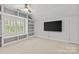 Bright bonus room with built-in shelving, a ceiling fan, and a wall-mounted TV for entertaining at 9513 Tresanton Dr, Charlotte, NC 28210