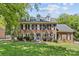 Charming two-story brick home featuring black shutters, dormers, mature landscaping, and a well-manicured lawn at 9513 Tresanton Dr, Charlotte, NC 28210