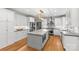 Modern kitchen featuring white cabinets, granite countertops, a center island with seating, and hardwood floors at 9513 Tresanton Dr, Charlotte, NC 28210