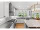 Gourmet kitchen featuring stainless steel appliances, white cabinets, granite countertops, and a stylish backsplash at 9513 Tresanton Dr, Charlotte, NC 28210