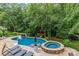 Inviting backyard pool and spa surrounded by lush landscaping and mature trees offers a private oasis at 9513 Tresanton Dr, Charlotte, NC 28210
