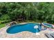 Stunning pool area with lush greenery, waterfall, and treehouse with hot tub, perfect for relaxation at 9513 Tresanton Dr, Charlotte, NC 28210