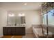Bright bathroom featuring double vanity with stone countertop, soaking tub, and glass enclosed shower at 9586 Kartey Nw Ave, Concord, NC 28027