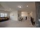 Upstairs bonus room with cozy furniture, neutral carpet, and natural light, perfect for entertaining or relaxing at 9586 Kartey Nw Ave, Concord, NC 28027