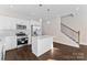A modern kitchen with stainless steel appliances, white cabinets, an island and luxury vinyl floors at 9713 Misenheimer Rd # 4A, Charlotte, NC 28215