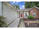 Inviting front porch with a bright red door, American flag, and a cozy bench at 1021 Stinson Glen Ln, Charlotte, NC 28214