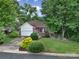 Charming home with a well-manicured front yard, a red door, and an attached garage at 1021 Stinson Glen Ln, Charlotte, NC 28214