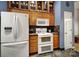 Kitchen area featuring a white refrigerator, an oven with stovetop, and ample cabinet space at 1021 Stinson Glen Ln, Charlotte, NC 28214