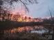 Picturesque view of a tranquil lake at sunset, reflecting vibrant colors in the water at 1021 Stinson Glen Ln, Charlotte, NC 28214