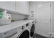 Clean and organized laundry room equipped with a modern washer and dryer, plus storage cabinets at 1021 Stinson Glen Ln, Charlotte, NC 28214