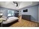 Bright main bedroom with hardwood floors, vaulted ceiling, and sliding barn door to the hallway at 1021 Stinson Glen Ln, Charlotte, NC 28214