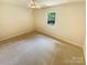 Empty bedroom featuring neutral carpet and a window providing natural light at 10701 Copper Field Dr, Pineville, NC 28134