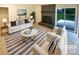 Bright living room featuring a brick fireplace, stylish furniture, and sliding doors to the backyard at 10701 Copper Field Dr, Pineville, NC 28134