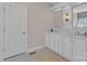 Bright bathroom boasts double sinks, shaker cabinets, tile floors, and an adjacent door at 11224 Warfield Ave, Huntersville, NC 28078