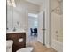 Well-lit bathroom features a tile floor, a toilet, and a shower-tub with a door to another room at 11224 Warfield Ave, Huntersville, NC 28078