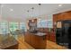Well-lit kitchen with an island, dark wood cabinets, granite countertops, and stainless steel appliances at 11224 Warfield Ave, Huntersville, NC 28078