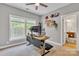 A bright office includes natural light from the large windows and a ceiling fan at 11224 Warfield Ave, Huntersville, NC 28078
