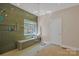 The glass enclosed shower includes tiled walls, tiled bench, and a large window at 11224 Warfield Ave, Huntersville, NC 28078
