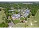 Aerial shot showcasing a golf course, tennis courts, swimming pool, and clubhouse, surrounded by lush greenery at 11510 Pine Valley Club Dr, Charlotte, NC 28277