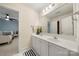 Bathroom featuring double sink vanity, white cabinets, modern lighting and carpet flooring at 11510 Pine Valley Club Dr, Charlotte, NC 28277