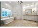Bright bathroom features a standalone tub, tile floors, and dual sconce lighting at 11510 Pine Valley Club Dr, Charlotte, NC 28277