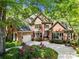 Stunning brick home featuring a well-manicured lawn, an attached garage, and a basketball hoop on the driveway at 11510 Pine Valley Club Dr, Charlotte, NC 28277