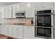 This kitchen features custom white cabinetry, stainless appliances, and granite countertops at 11510 Pine Valley Club Dr, Charlotte, NC 28277