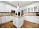 Modern kitchen with white cabinets, granite countertops, hardwood floors, and stainless steel appliances at 11510 Pine Valley Club Dr, Charlotte, NC 28277