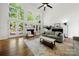Bright living room with soaring windows, a fireplace, hardwood floors, and comfortable sofas at 11510 Pine Valley Club Dr, Charlotte, NC 28277