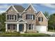 Beautiful two-story stone and brick home featuring a symmetrical design and manicured landscaping at 11913 Casabella Dr, Huntersville, NC 28078